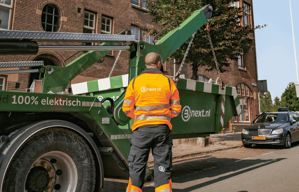 Vrachtwagen chauffeur die een afvalcontainer in een straat plaatst