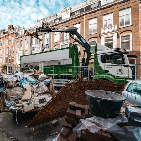 Afval van een bouwplaats wordt opgehaald door een Bnext.nl wagen.